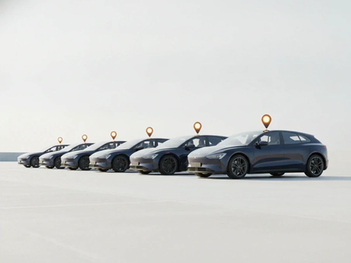 Fila de carros escuros iguais estacionados, cada um com um marcador dourado acima